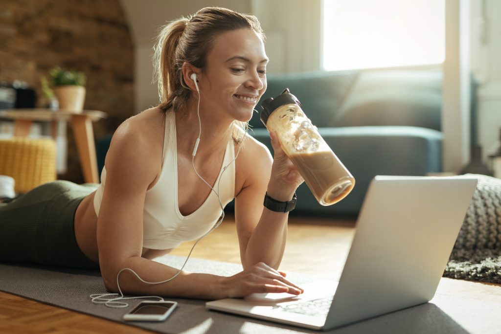Los Mejores Suplementos Alimenticios En 2023 - Descúbrelos En Pro Salud &Raquo; Prosalud Joven Deportista Feliz Bebiendo Batido Mientras Relaja Suelo Navega Red Computadora Portatil