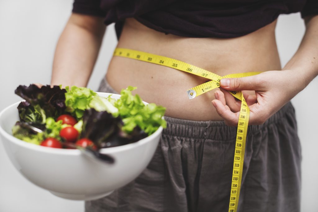 Los mitos detrás de las dietas milagro | 2024 2 mujer midiendo su barriga peso