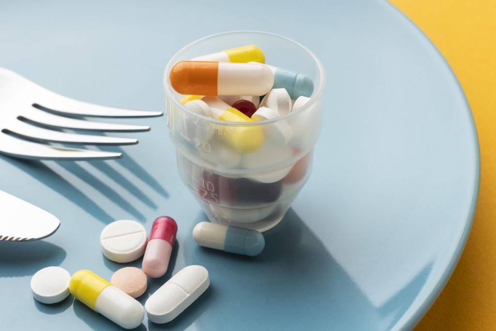 Cómo elegir los suplementos alimenticios adecuados 4 high view glass filled with pills
